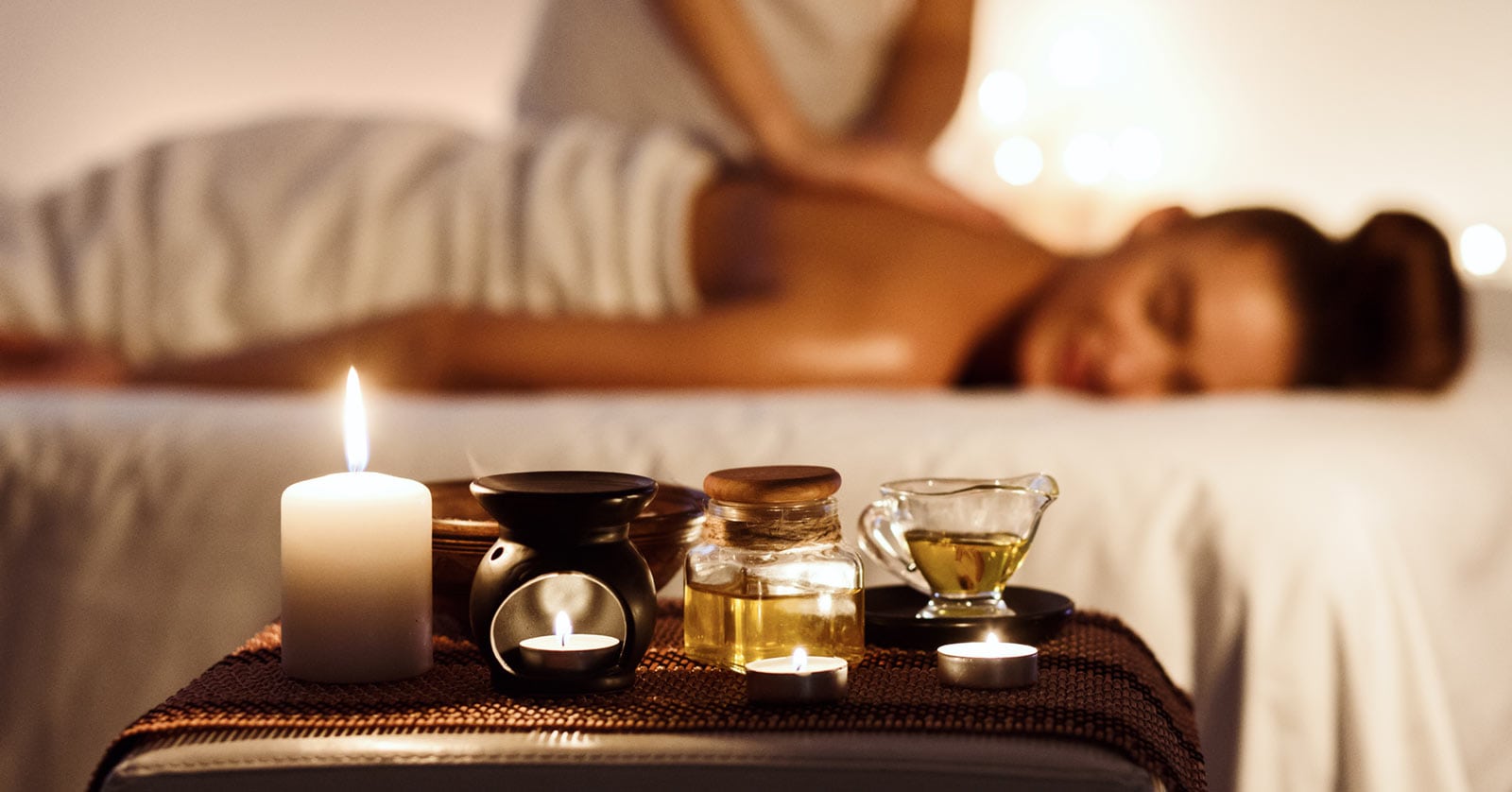 Bulk Products for Spas in South Africa. Woman on massage table, with bottles of essential massage oils